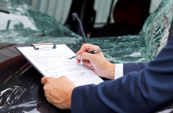 insurance assessor inspecting damaged vehicle