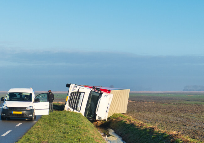 overturned truck on the side of the road.