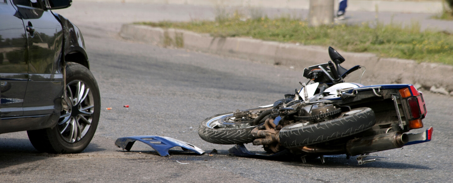 car and motorcycle accident on a road.