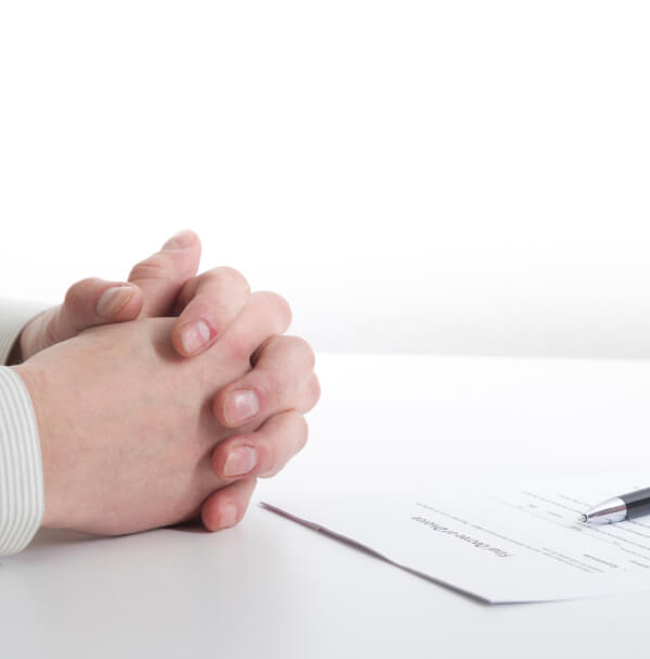 crossed arms on the table before signing papers.